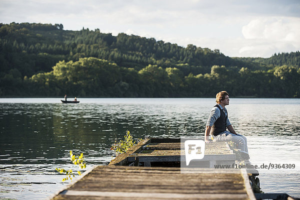 Deutschland  Rheinland-Pfalz  Laacher See  Mann auf Holzsteg sitzend