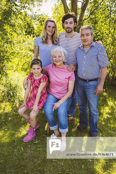 Porträt einer Drei-Generationen-Familie im Garten