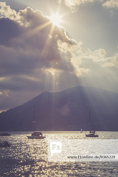 Italien  Veneto  Brenzone  Segelboote auf dem Gardasee gegen die Sonne
