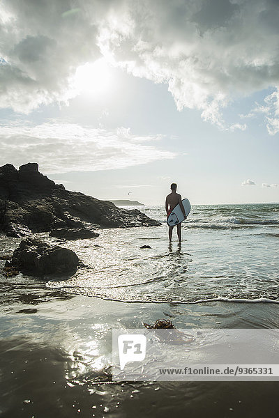 Frankreich  Bretagne  Camaret-sur-Mer  Teenager mit Surfbrett am Meer
