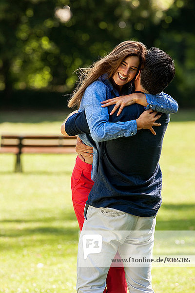 Ein Paar umarmt sich im Park.