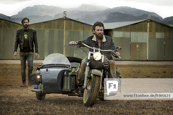 Zwei Männer mit Vollbart mit Motorrad mit Beiwagen
