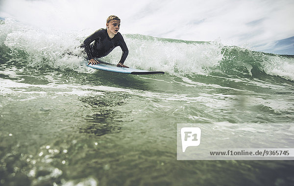 France  Bretagne  Camaret sur Mer  Teenage boy surfing at Atlantic coast