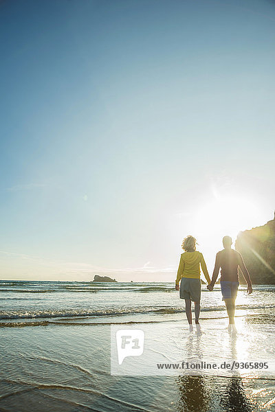 Frankreich  Bretagne  Camaret-sur-Mer  Teenager-Paar am Strand  das im Meer watet.