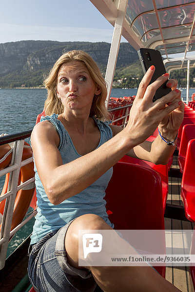 Italien  Gardasee  Frau mit Selfie auf dem Tourboot