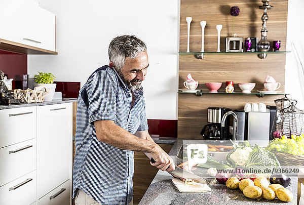 Österreich  Mann in der Küche mit Smartphone