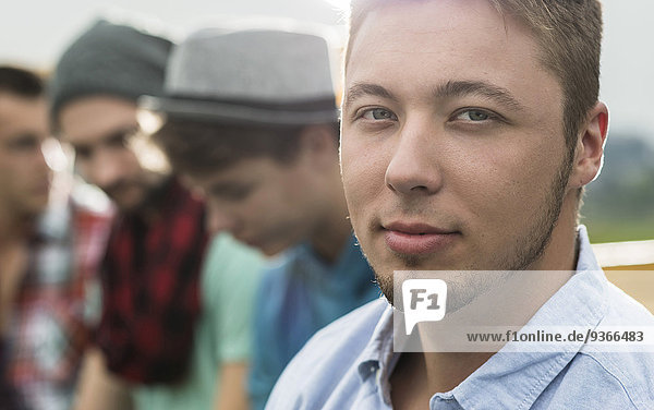 Portrait of young man with friends in background