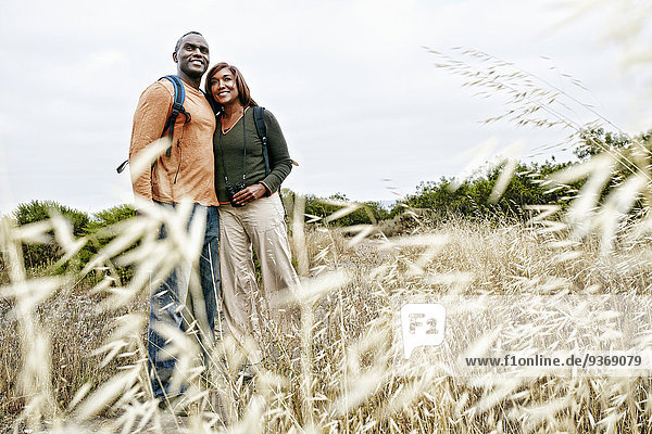 Black couple smiling on rural hillside