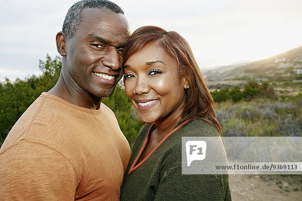 Black couple smiling on rural hillside