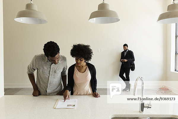 Couple reading paperwork in new house