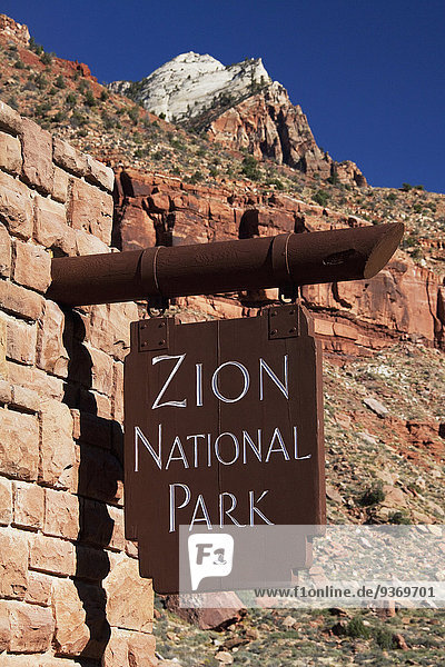 Close up of Zion National Park sign on stone wall  Utah  United States