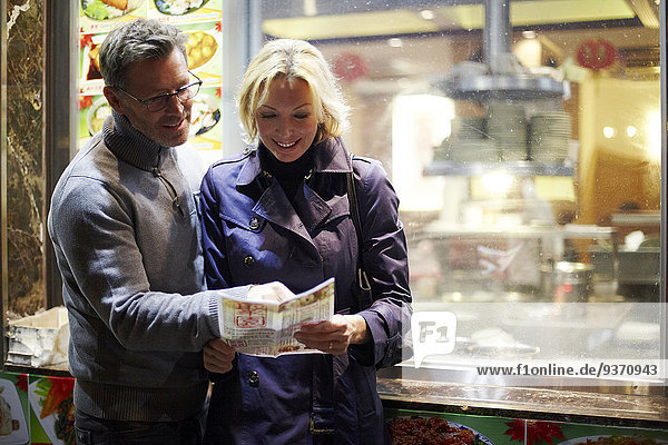 Caucasian couple reading menu at food cart  New York City  New York  United States