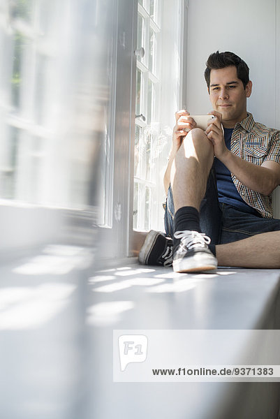Mann sitzt am Fenster