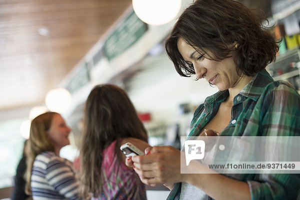 A woman in a diner  looking at her cell phone.