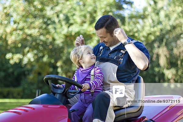 Father and daughter on a lawnmower