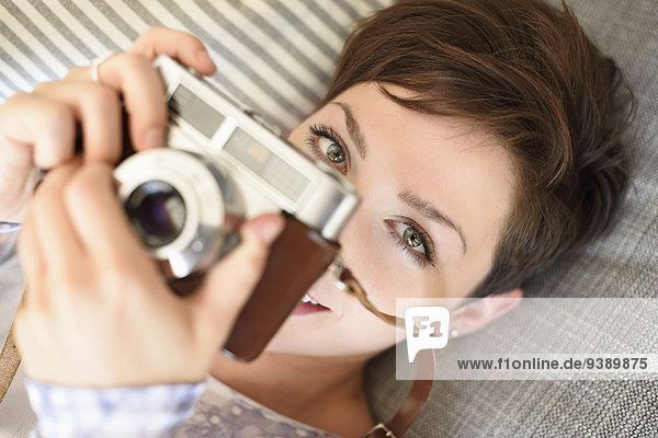 Portrait of young woman holding old fashioned camera