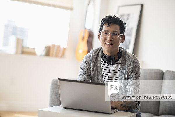 Portrait of man with headphones in front of laptop