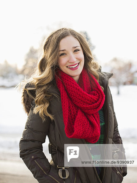Portrait of woman wearing red scarf smiling outdoors