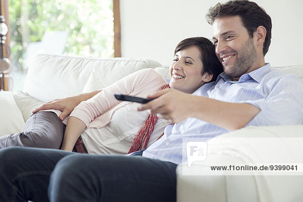 Couple watching TV together on sofa