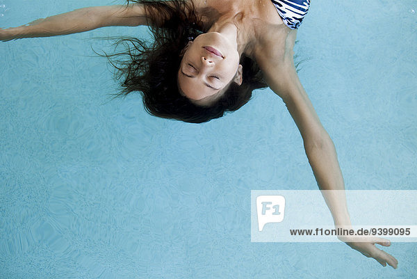 Schwimmende Frau im Pool mit geschlossenen Augen