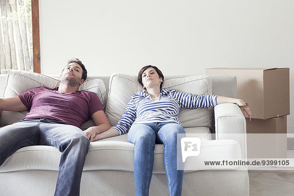 Pärchen beim Umzug auf dem Sofa entspannen