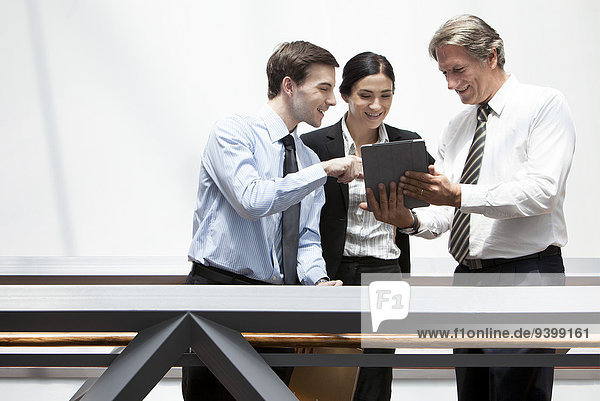 Business colleagues looking at digital tablet together