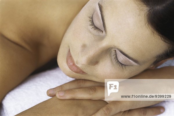 Woman resting head on hands  eyes closed