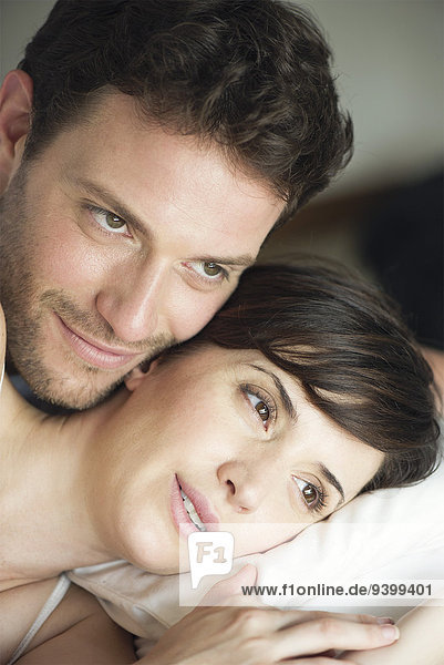 Couple in bed together comtemplating future plans