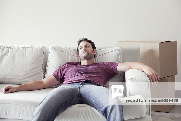 Man relaxing on sofa while moving house