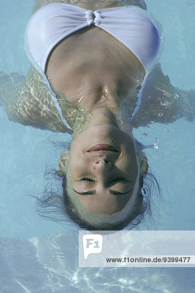 Junge Frau im Schwimmbad schwimmend  Augen geschlossen