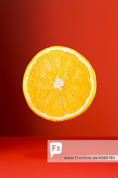 Orangenscheibe auf roter Theke