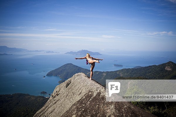 Frau Steilküste üben hoch oben Yoga