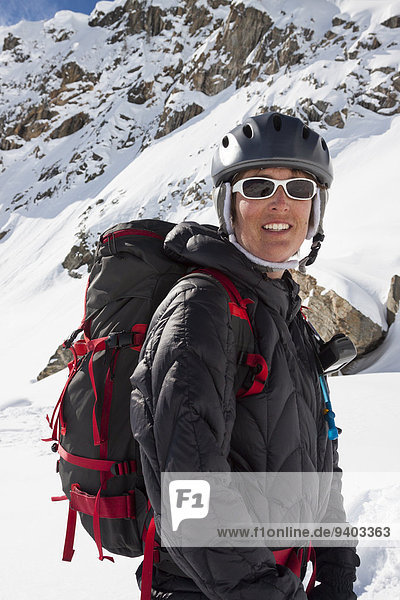 A female backcountry skier smiles after skiing powder in the Beehive Basin near Big Sky  Montana.