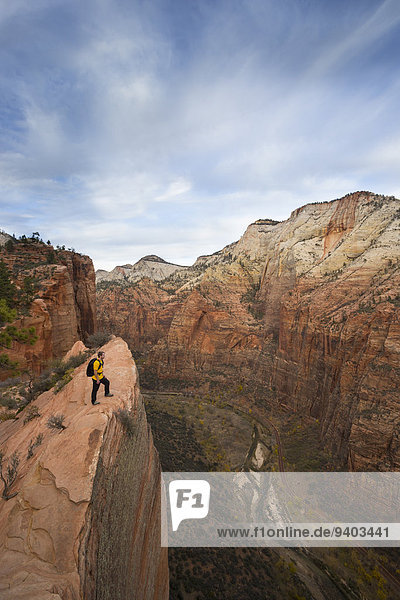 A hiker looks out over Zion from the Angels Landing trail.