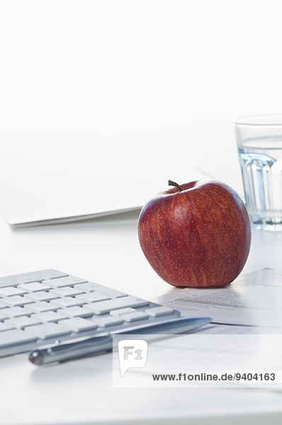 Apfel  Tastatur und Glas auf dem Schreibtisch