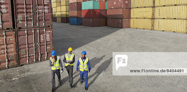 Geschäftsleute und Arbeiter in der Nähe von Frachtcontainern