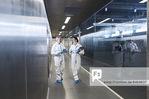 Scientists in clean suits walking in hallway
