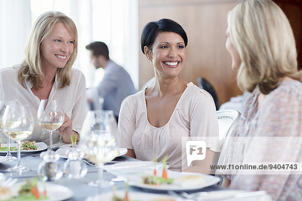 Fröhliche Frauen im Restaurant  Mann im Hintergrund