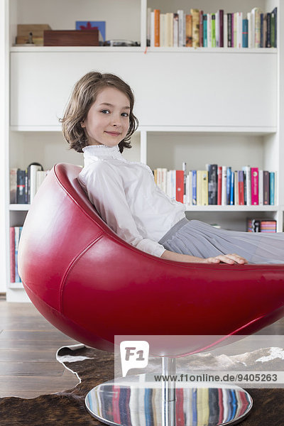 Portrait of girl sitting on chair  smiling