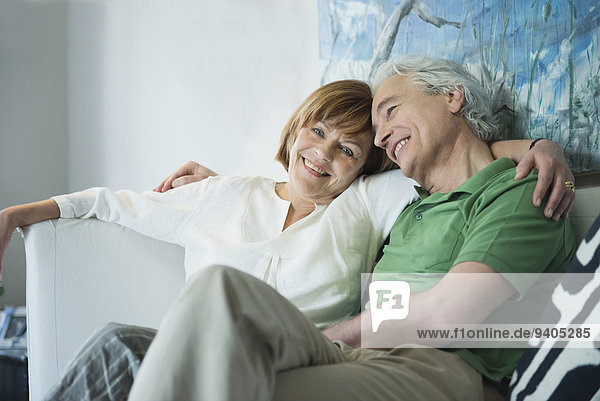 Couple relaxing on couch  smiling