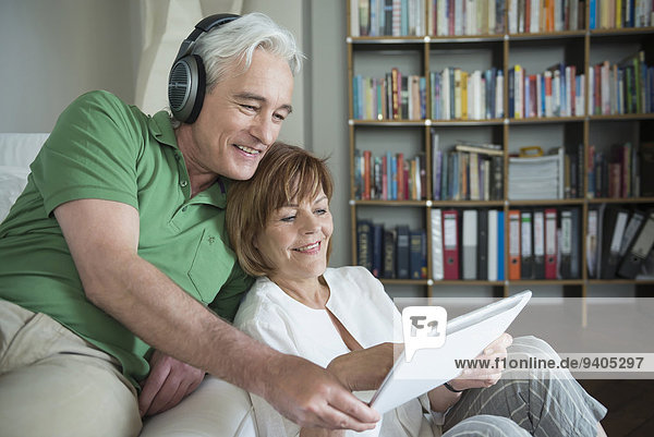 Couple using digital tablet while man with headset  smiling
