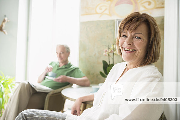 Portrait of senior woman smiling while mature man in background