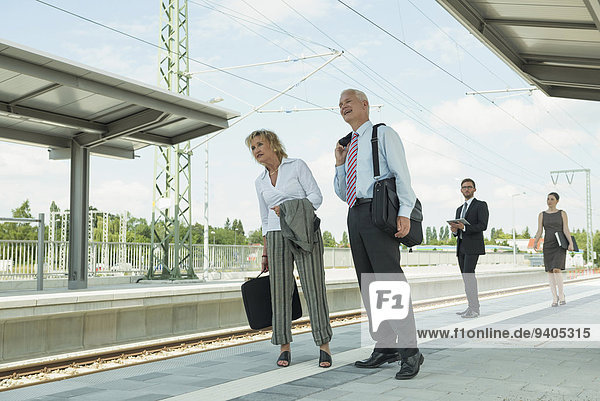 Four businessmen waiting for train