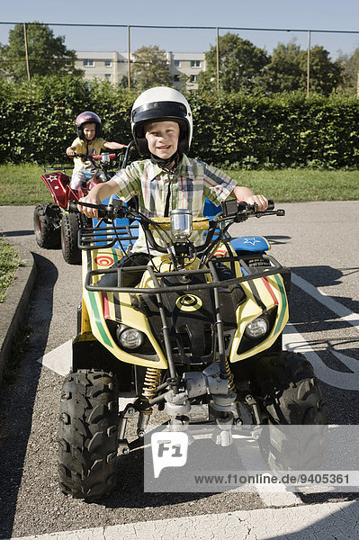 Two boys with quadbikes on driver training area
