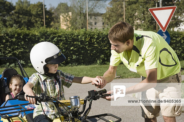 Tutor explaining quadbike to boy on driver training area