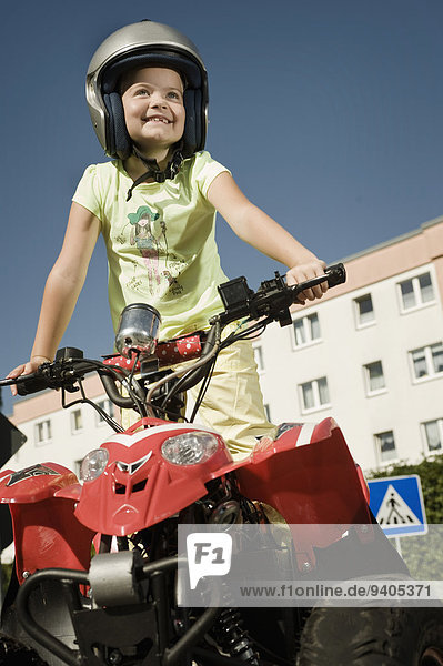 Smiling girl with quadbike on driver training area