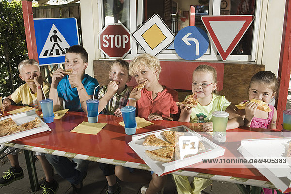 Children eating pizza at driver training area