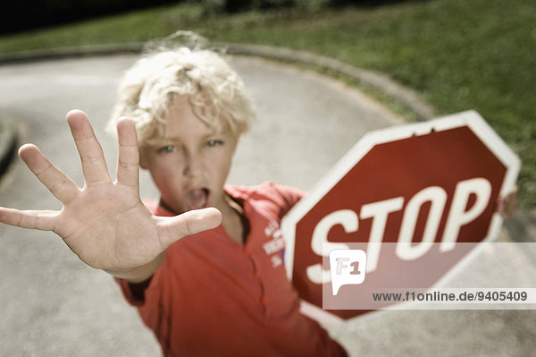 Boy on driver training area holding stop sign