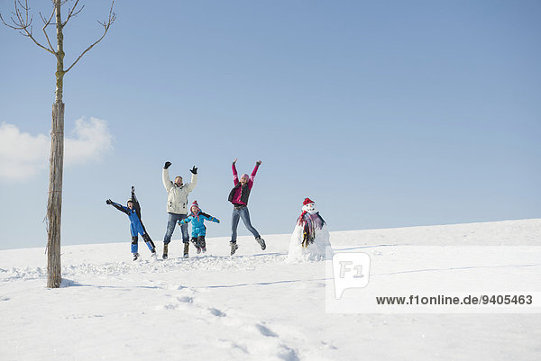 Family jumping on snow