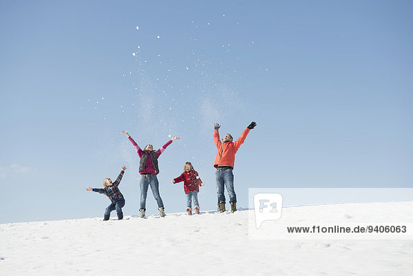 Family playing with snow in winter